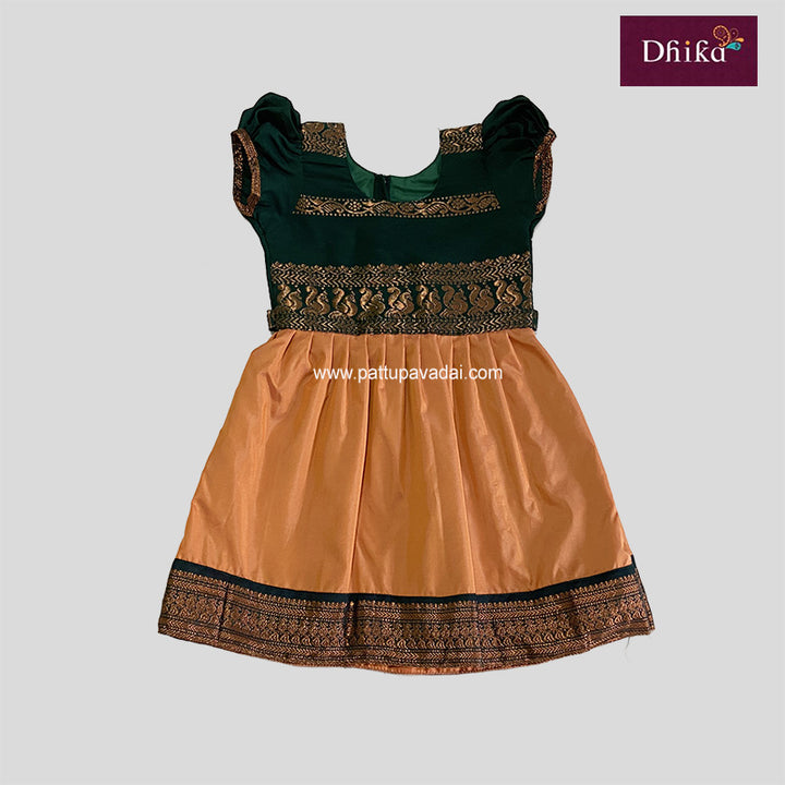 A traditional Kalyani cotton frock in orange and green with floral patterns and a green border.