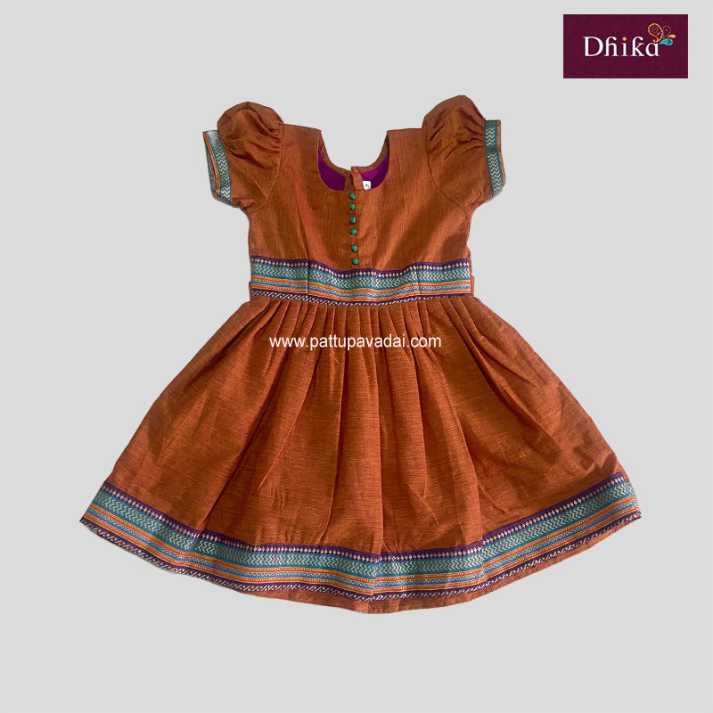 A Honey Brown colored cotton frock dress with short puffed sleeves, a round neckline, and a multicolored striped pattern around the waist.