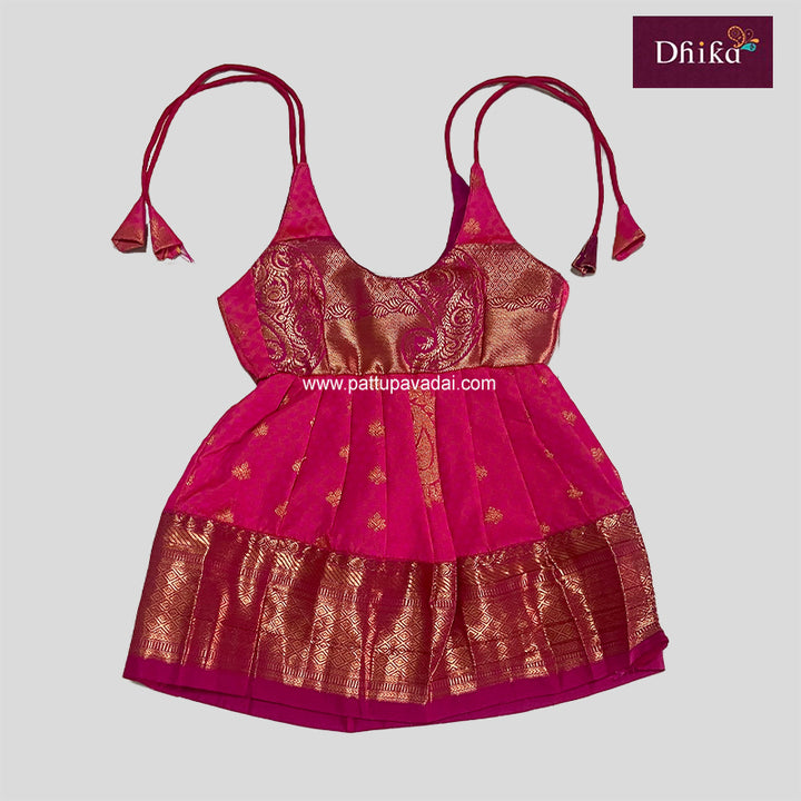 A traditional Indian pink silk frock with golden and red floral patterns and pleated design.