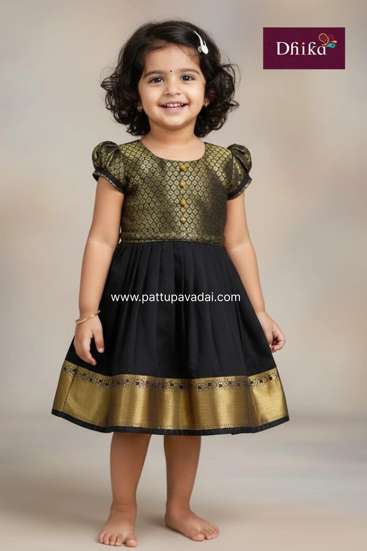 Young girl wearing a black and gold dress with 'Dhika' branding.