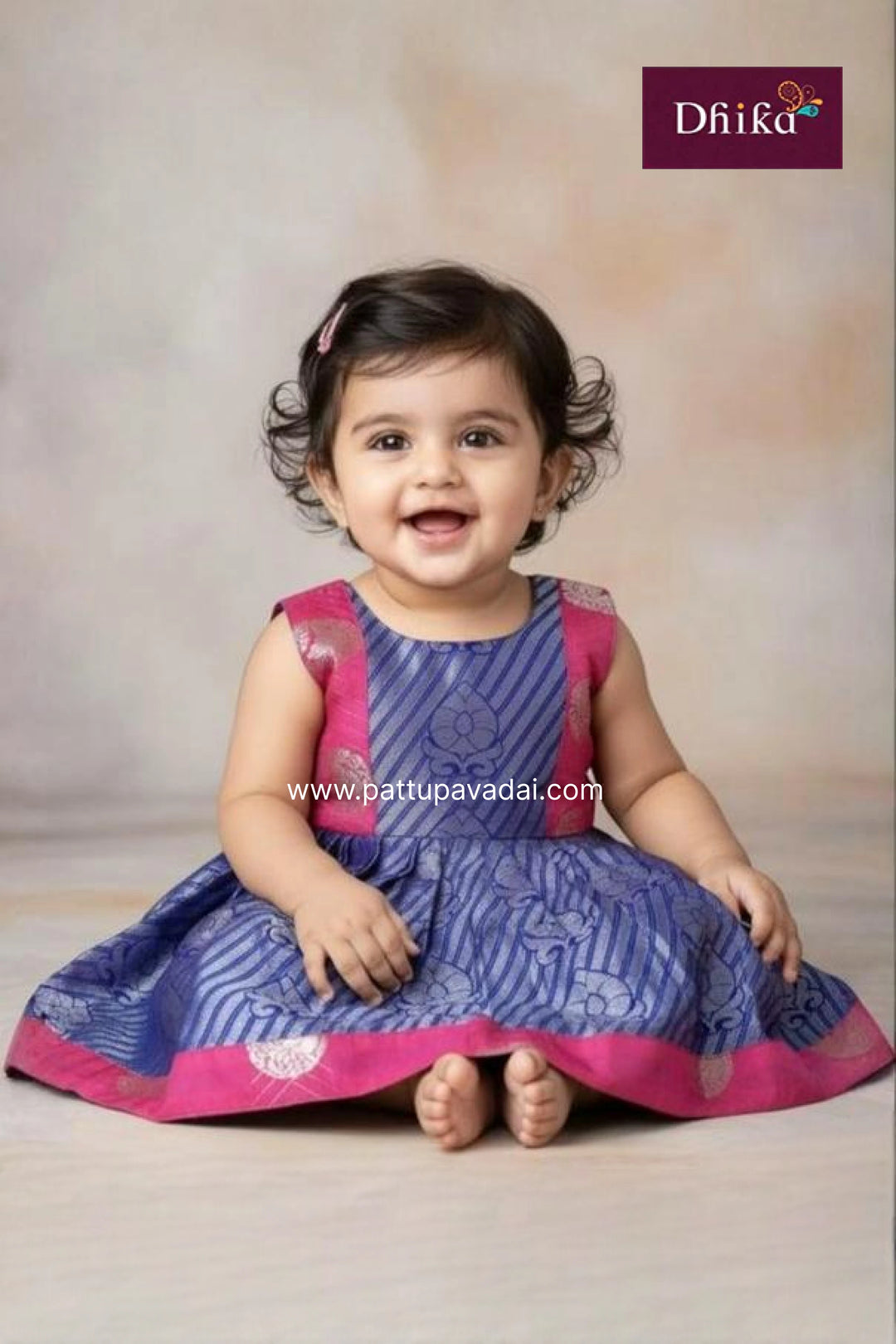 Child wearing a blue and pink traditional outfit with a Dhiika brand logo in the corner.