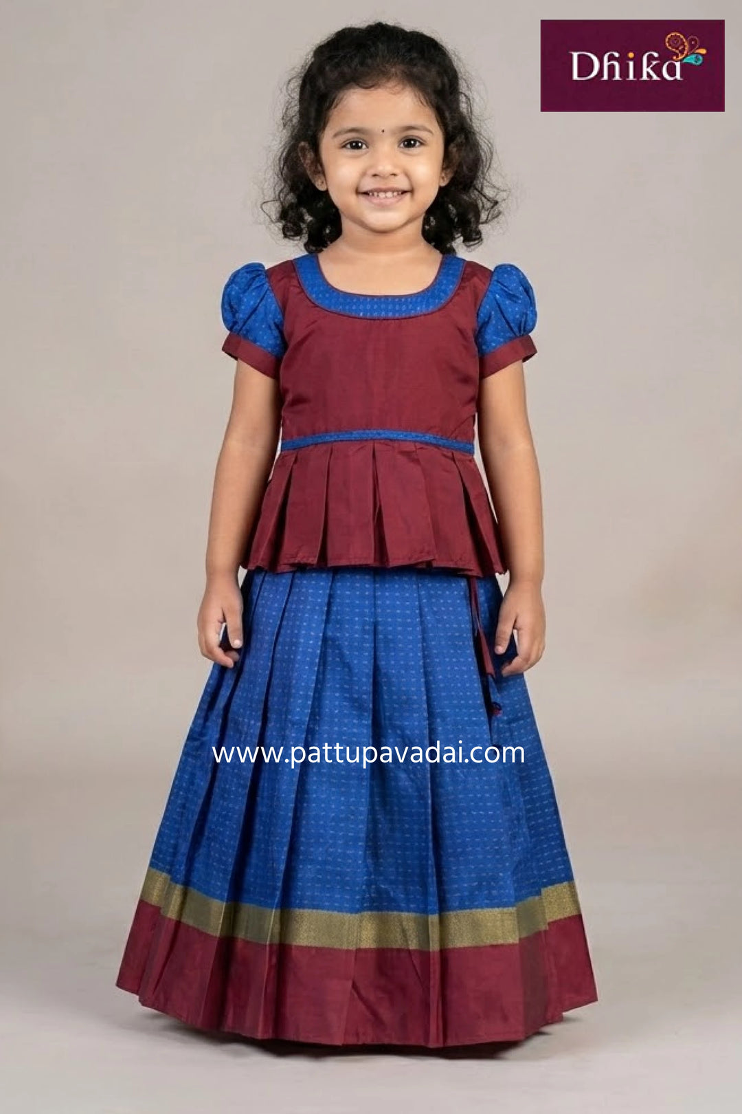 Young girl wearing a navy blue and pink traditional outfit with Drika branding.