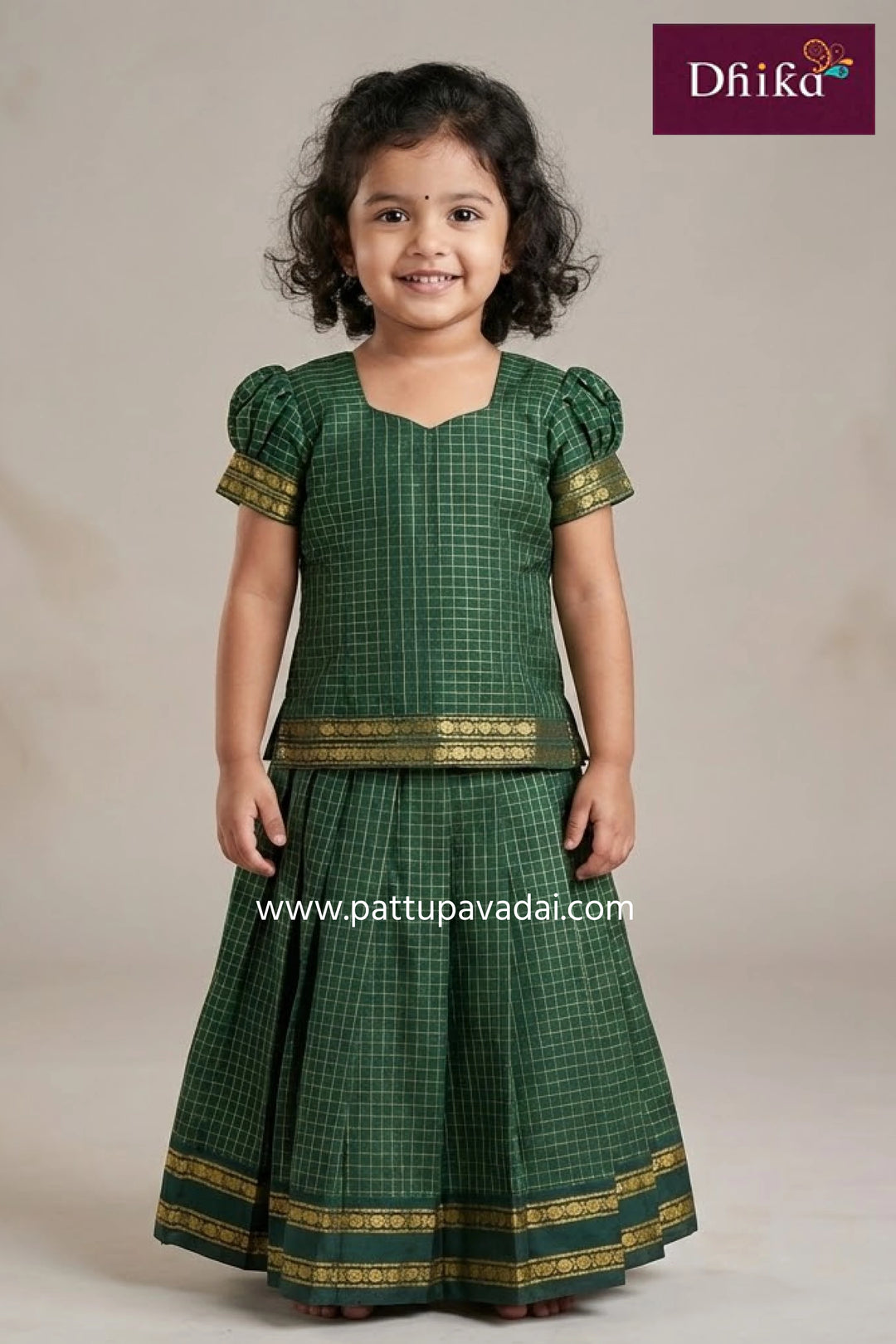 Baby wearing a blue and white traditional outfit with colorful patterns, sitting on a light gray background.
