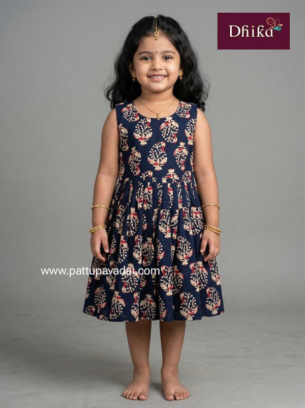 Young girl wearing a navy blue dress with floral patterns on a gray background, branded 'Dhika'.