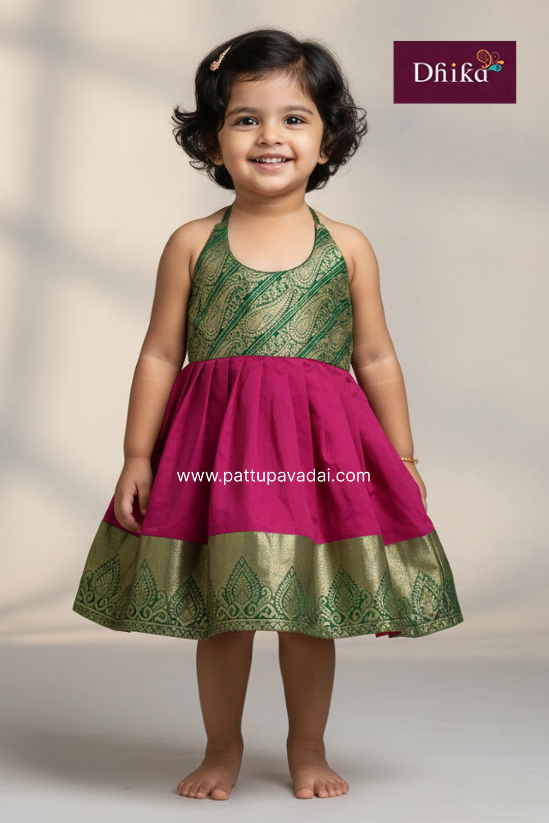 Young girl wearing a pink and green traditional dress with Dfiika branding.