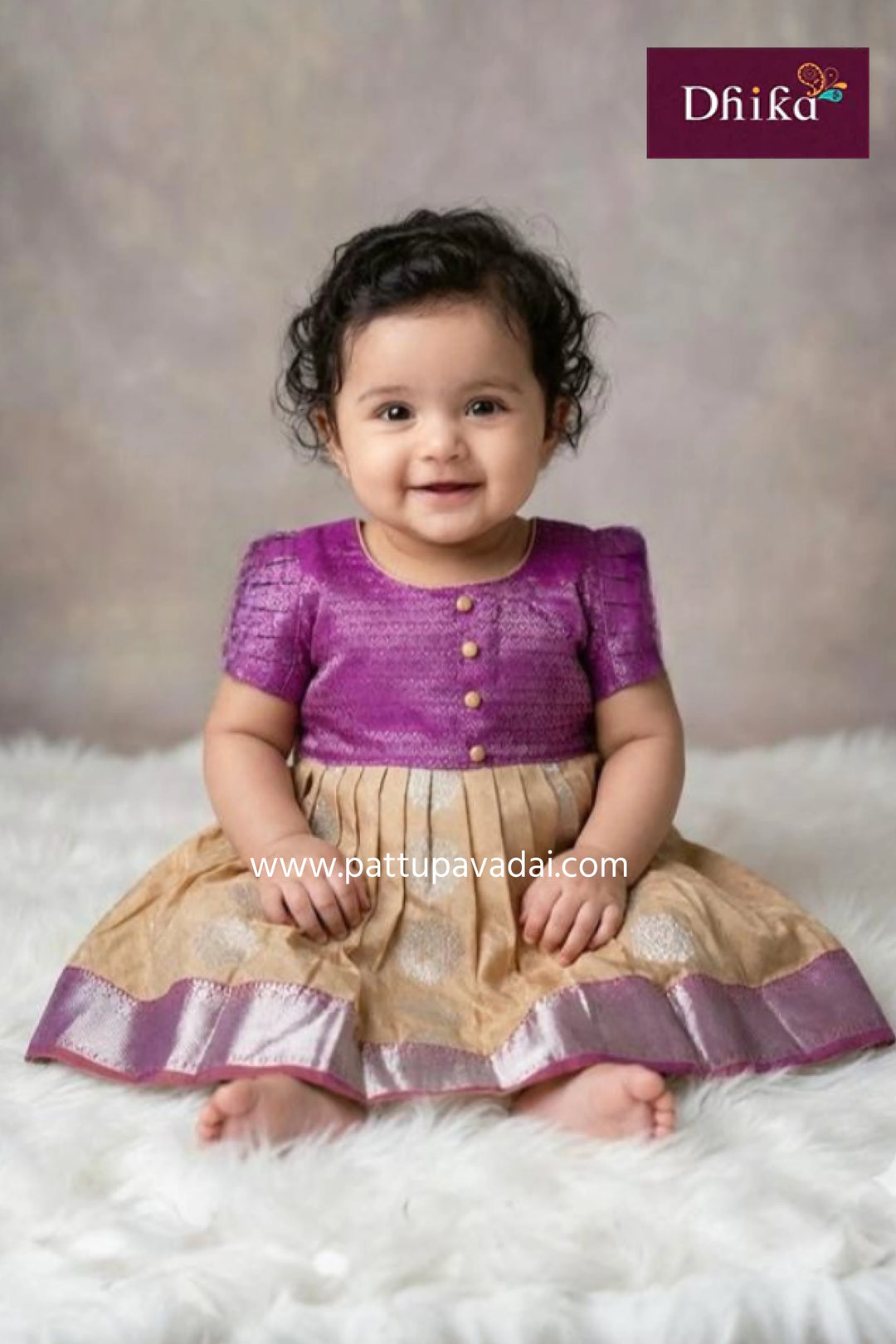 Child wearing a purple and beige traditional outfit with 'Dhika' branding.