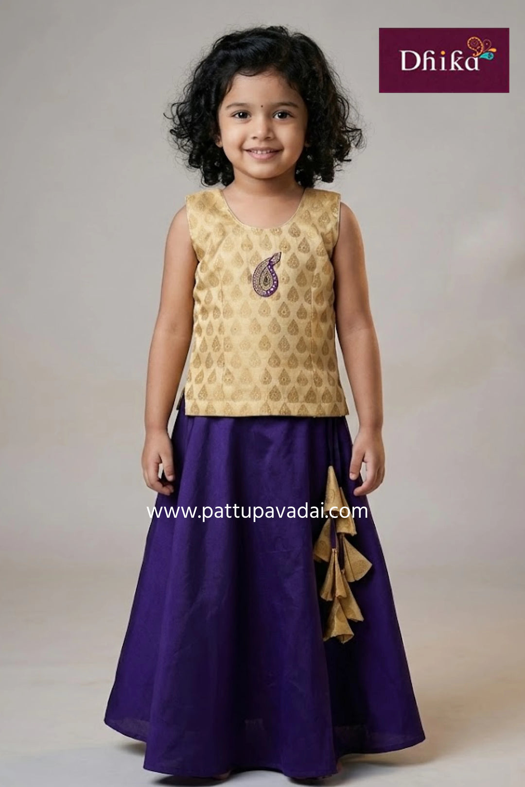 Young girl wearing a gold top and purple skirt with 'Dhika' branding.