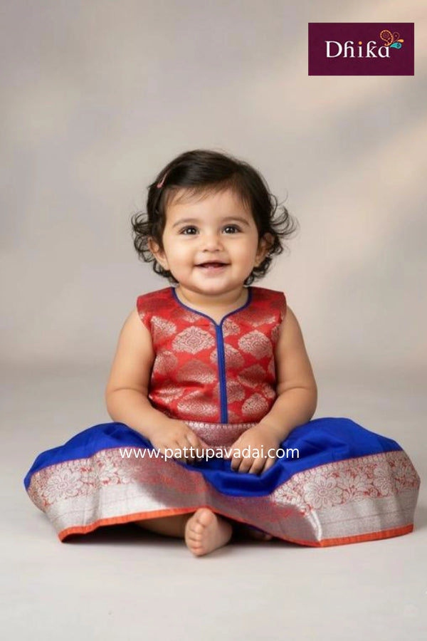 Young girl wearing a blue and pink traditional outfit with 'Dhika' branding.