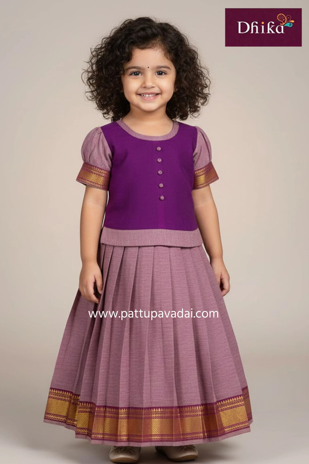 Young girl wearing a purple traditional outfit with gold accents, standing against a plain background.