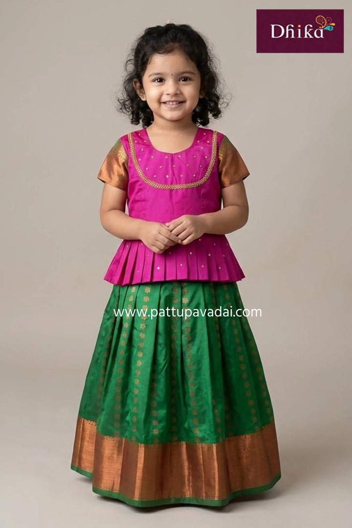 Young girl wearing a traditional outfit with a maroon and gold pattern, standing against a plain background.
