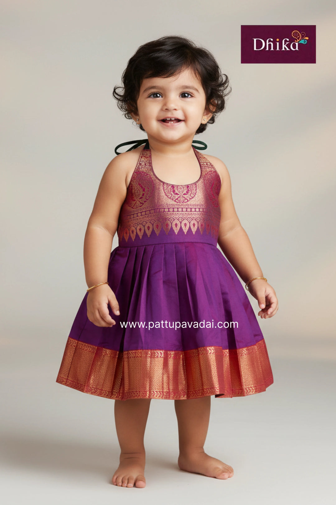 Child wearing a purple dress with intricate patterns on a plain background