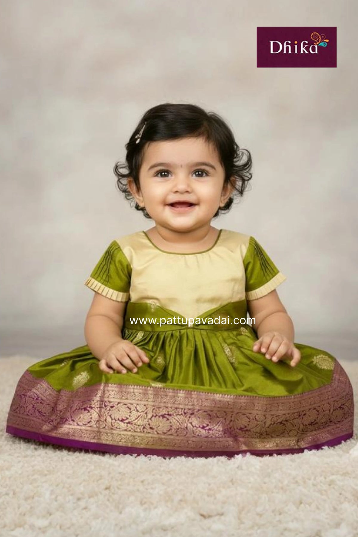 Child wearing a green traditional outfit with a Dhiika brand logo in the corner.