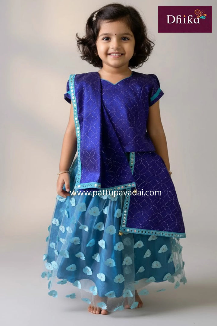 Young girl wearing a blue traditional outfit with a matching dupatta, standing against a plain background.