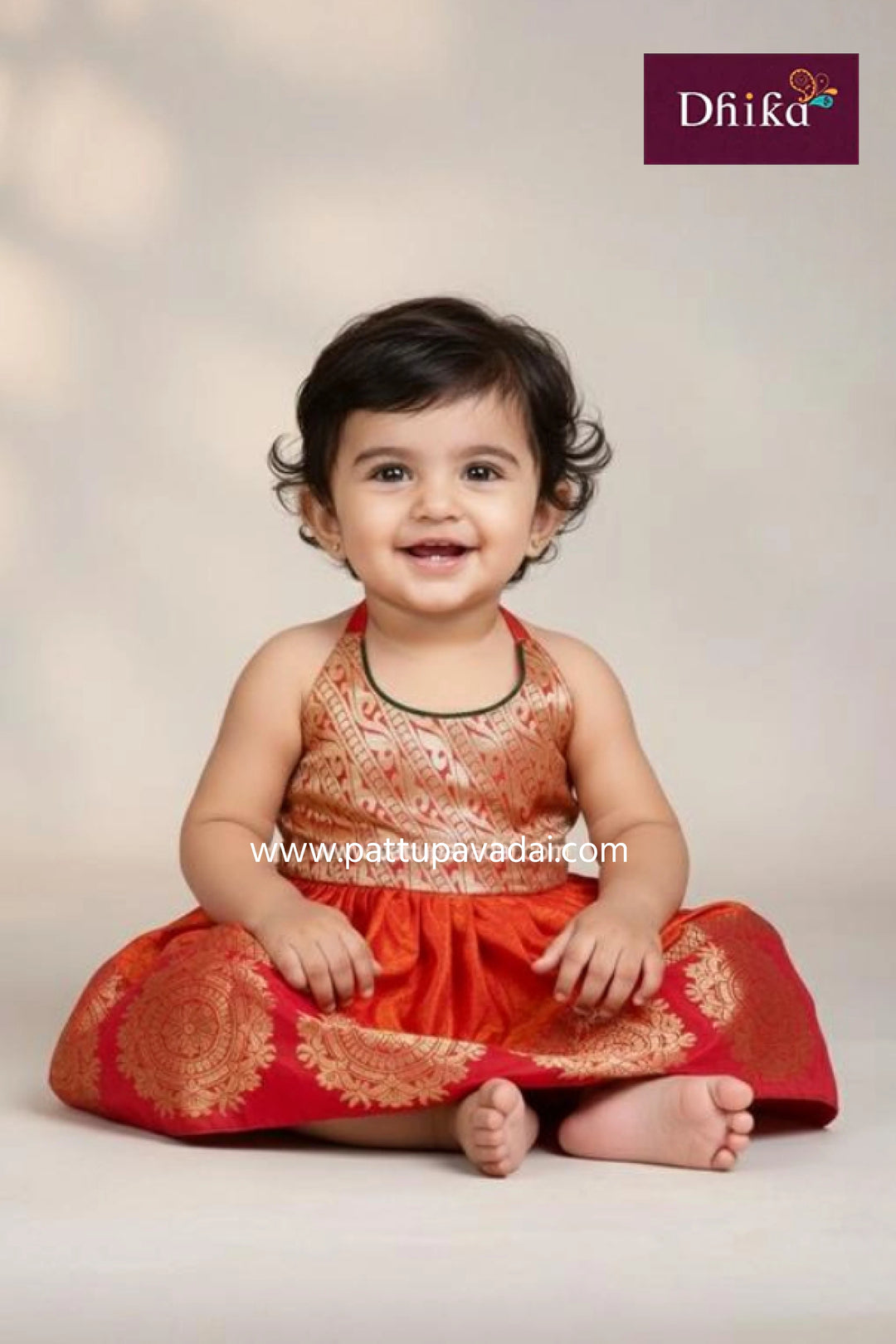 Baby wearing a traditional outfit with a visible brand logo on a plain background