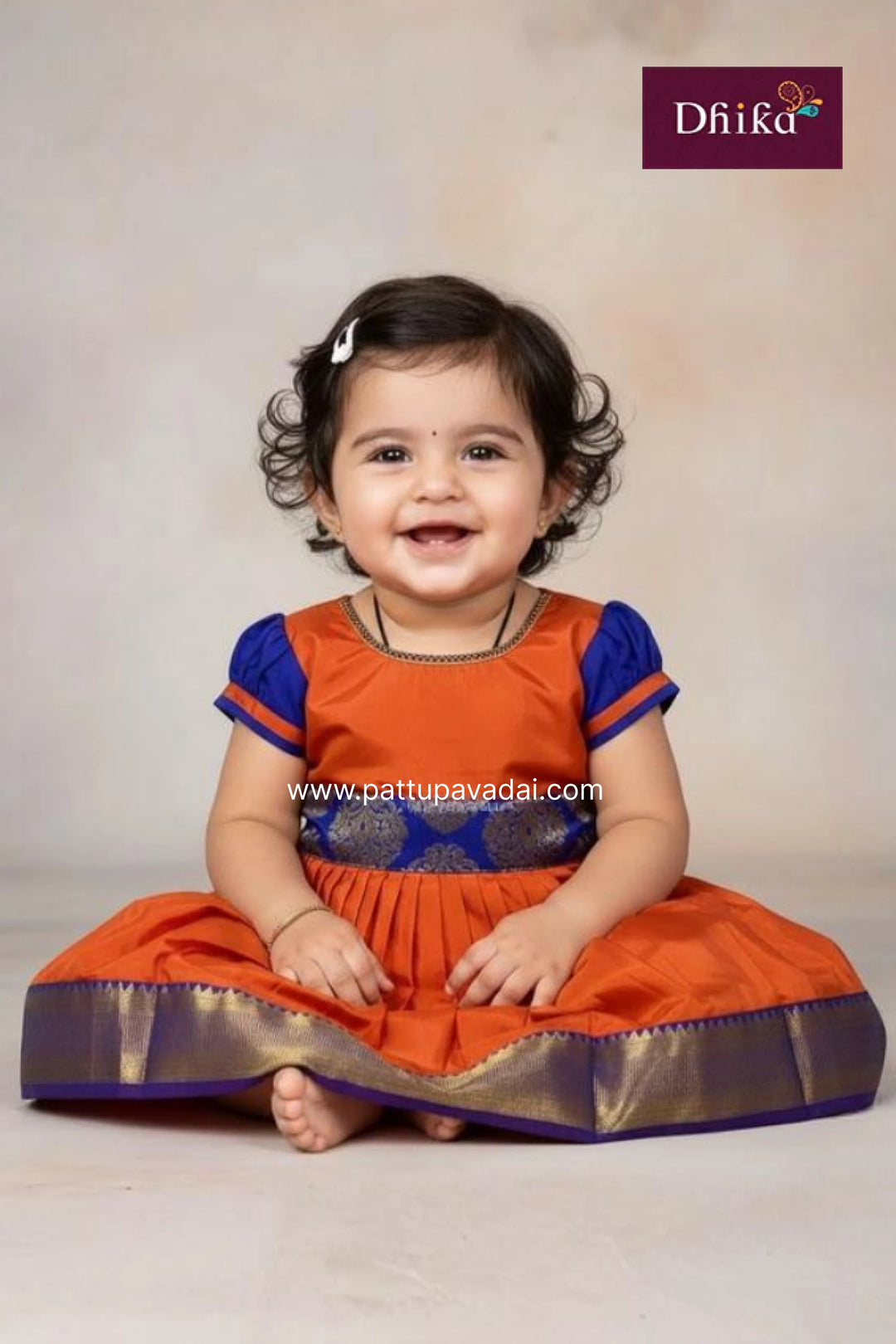 Child wearing an orange and blue traditional outfit with a white background