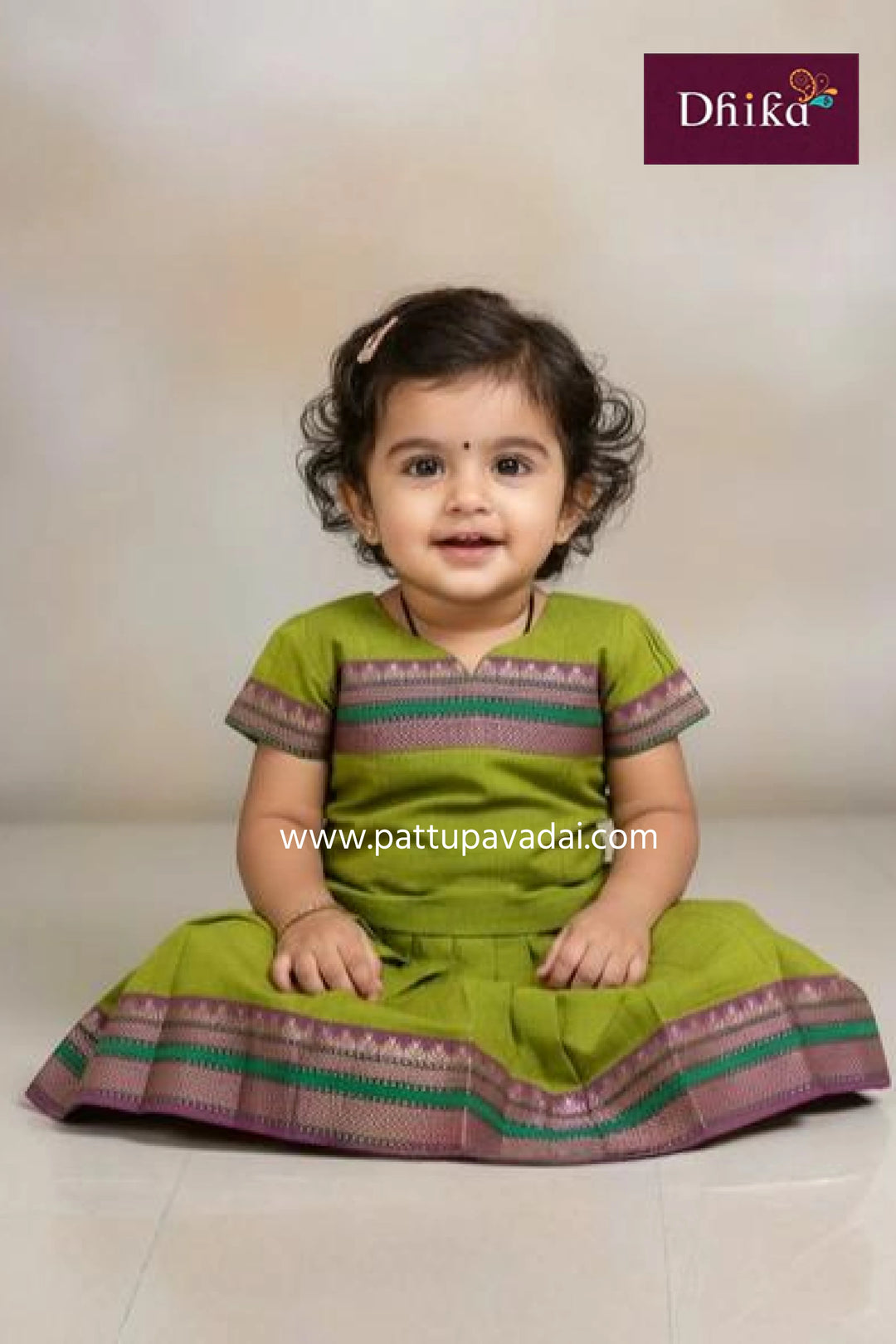 Child wearing a green traditional outfit with a white background