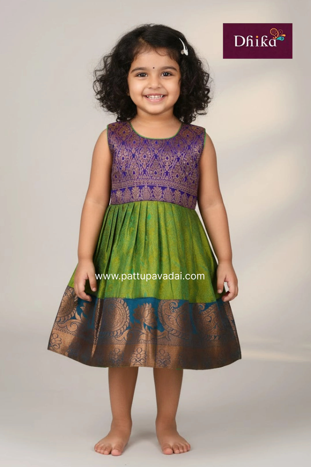 Young girl wearing a green and purple dress with 'Dhika' branding on a white background