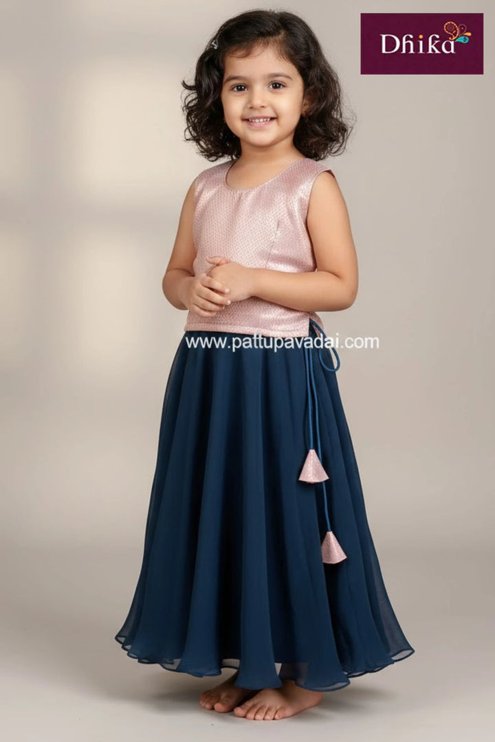 Young girl wearing a pink top and navy blue skirt with 'Dhika' branding.