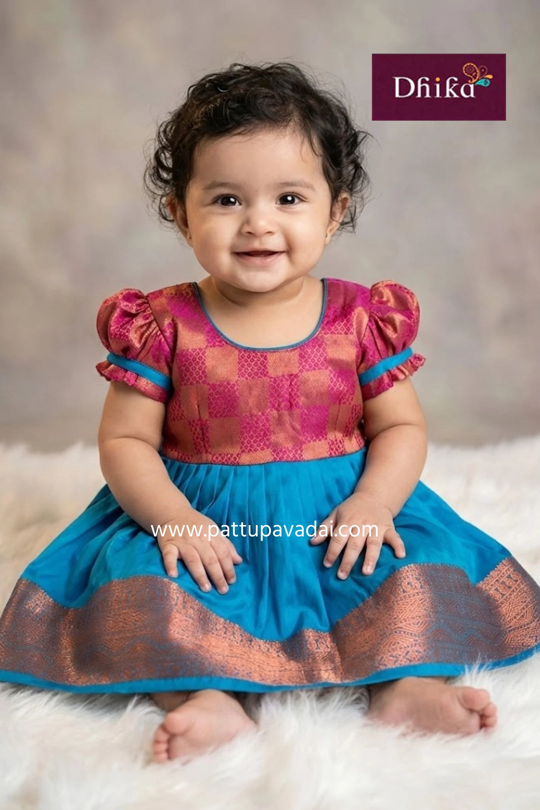 Child wearing a colorful traditional outfit with 'Dhika' branding