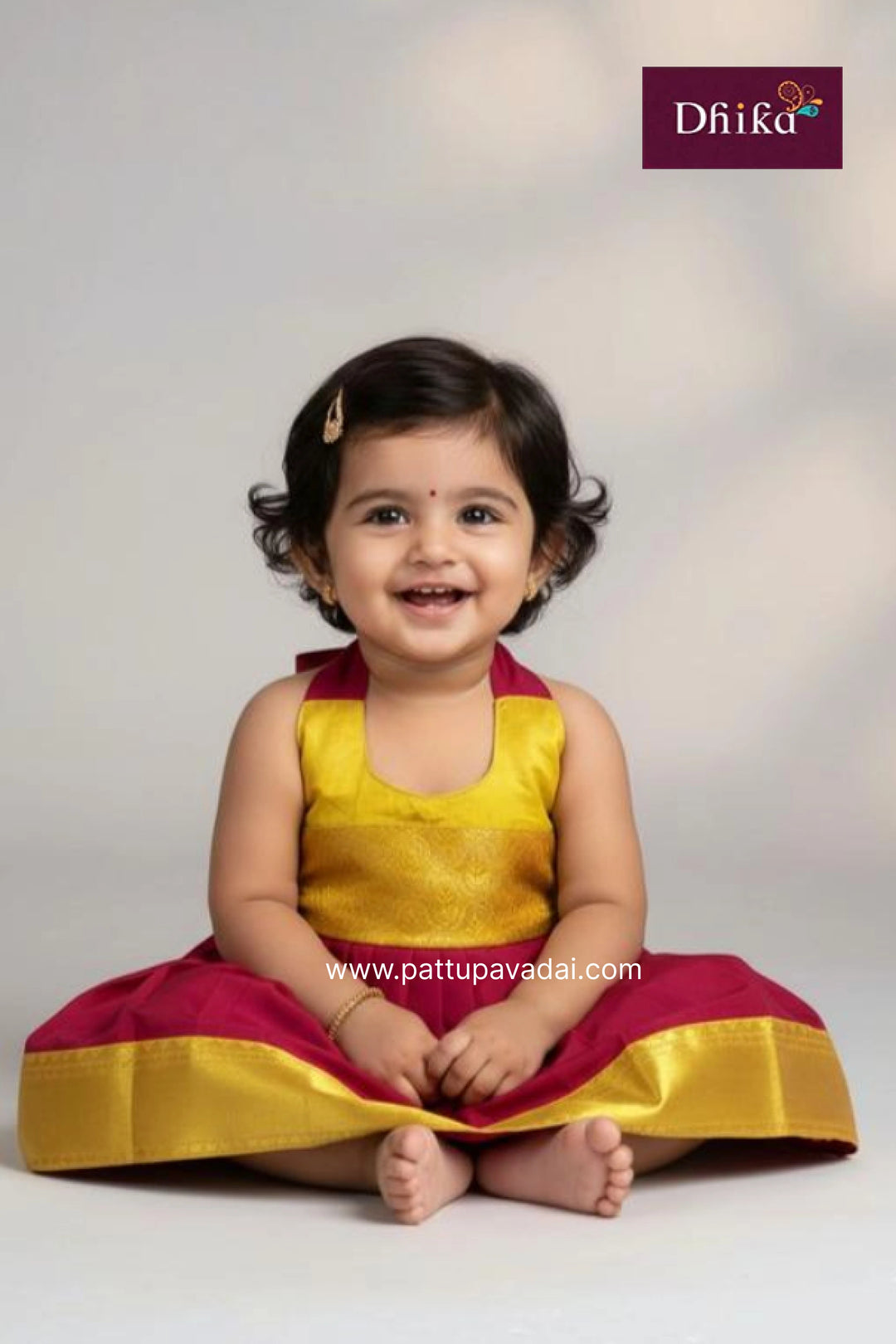 Child wearing a yellow and red traditional outfit with 'Dhika' branding.