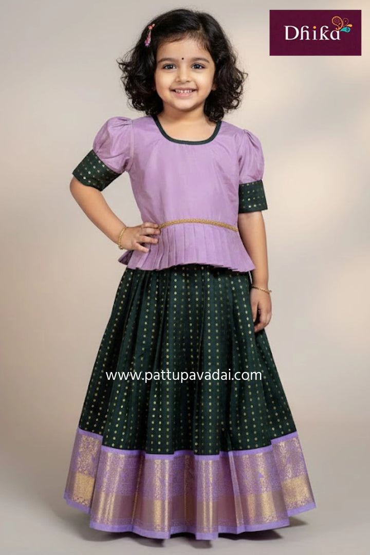 Young girl wearing a purple and green traditional outfit with 'Dhika' branding.