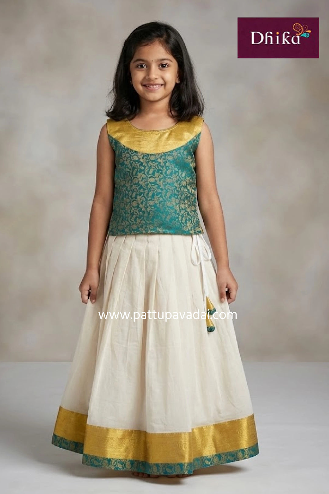 Young girl wearing a traditional outfit with green top and white skirt, brand 'Dhika' visible.