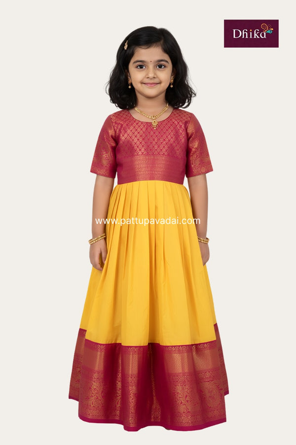 Young girl wearing a red and yellow traditional outfit with 'Dhika' branding.