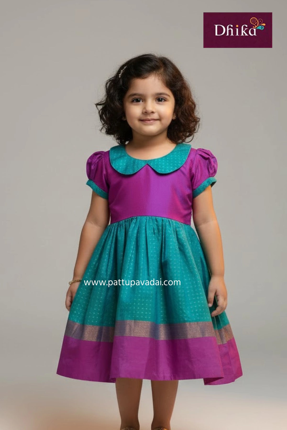 Young girl wearing a purple and teal dress with 'Dhika' branding on a gray background