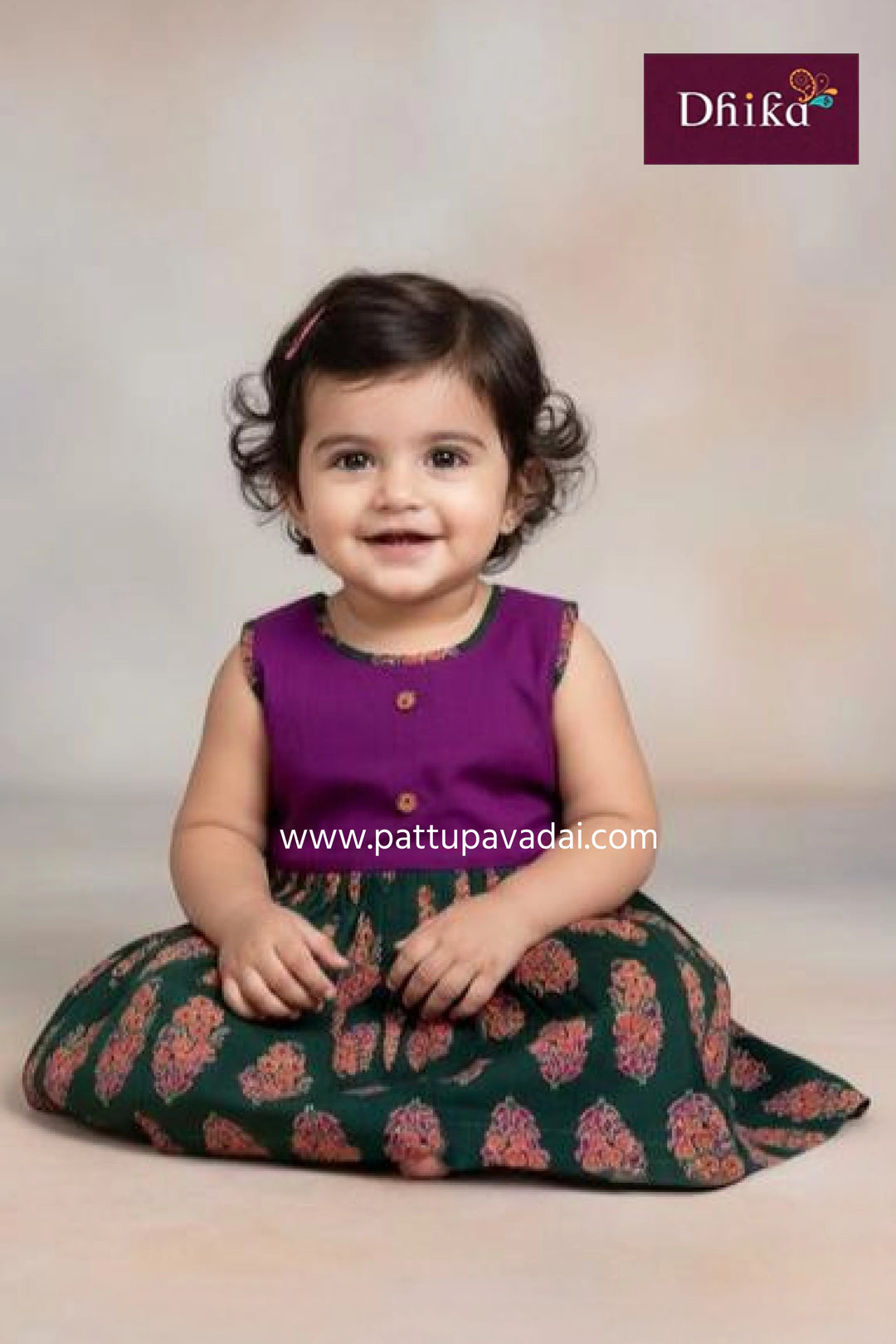 Child wearing a purple top and green floral skirt with a plain background
