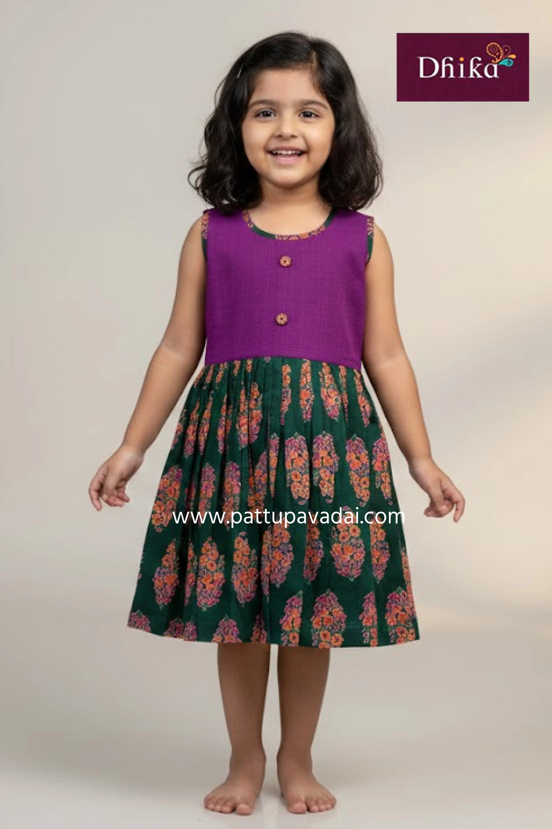 Young girl wearing a purple top and patterned skirt with 'Dhika' branding.