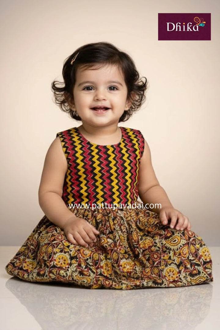 Child wearing a colorful dress with a pattern, sitting on a light background.