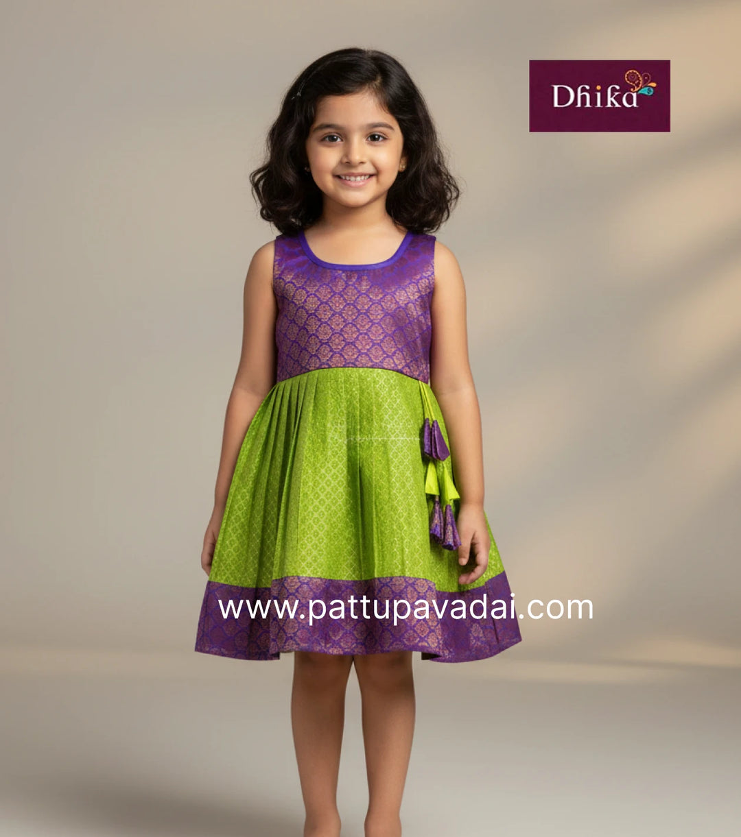 Young girl wearing a purple and green dress with 'Dhika' branding on a gray background.