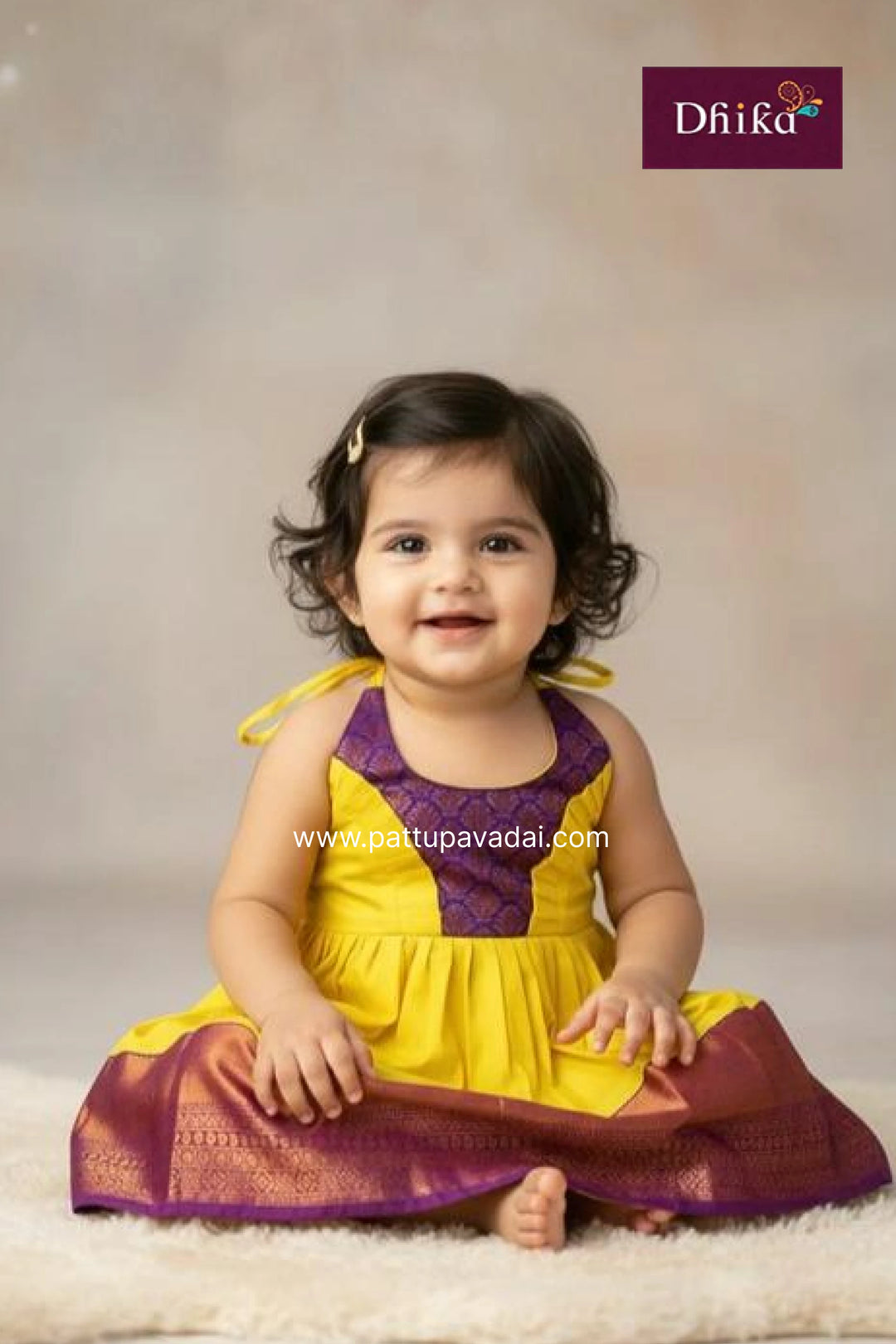 Child wearing a yellow and purple traditional outfit with Dhiika branding.