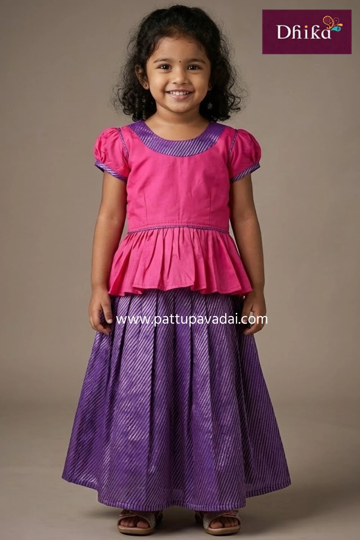 Young girl wearing a pink top and purple skirt with 'Dhika' branding.