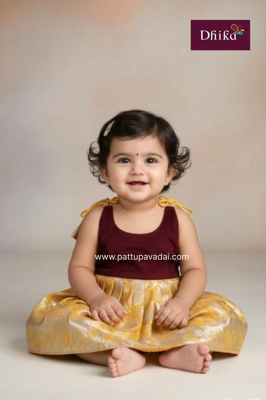 Child wearing a traditional outfit with a plain background and Dhika brand logo.