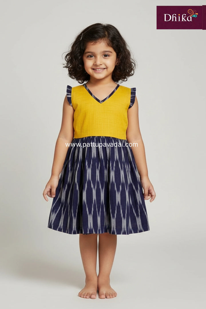 Young girl wearing a yellow and navy dress with 'Dhika' branding on a white background