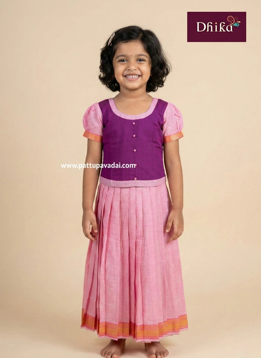 Young girl wearing a purple top and pink skirt with 'Dhika' branding.